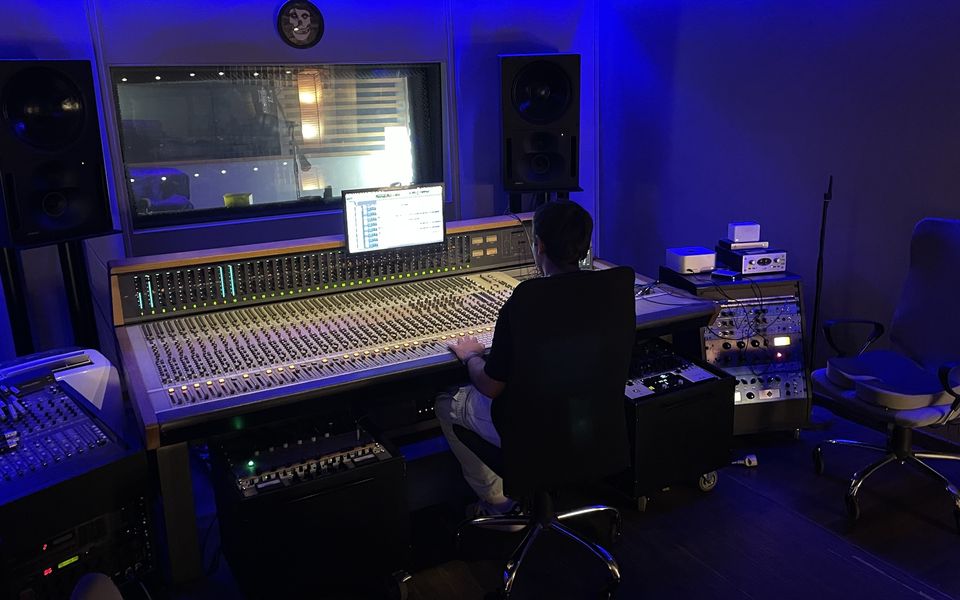 Productor musical de rock mezclando una canción en la consola del estudio, en Madrid